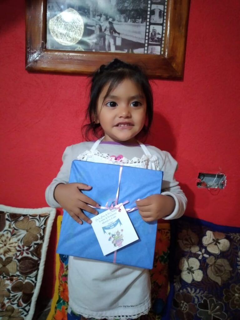 Niña con un regalo de CASA