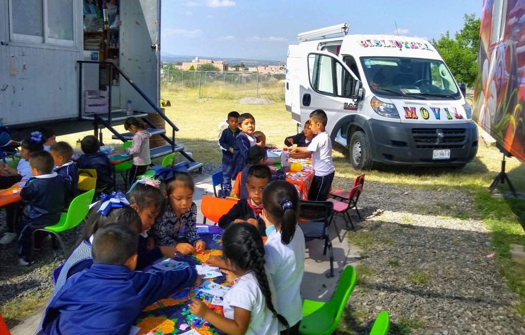 Children reading by the Mobile Library